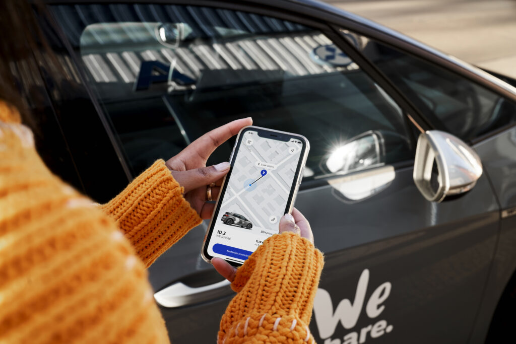 Mockup of the WeShare app in the hand in front of a car